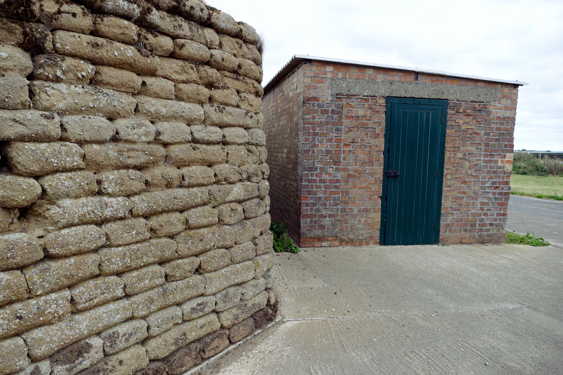 Close up of original WW2 fighter pen with concrete sandbank walls and brick shelter