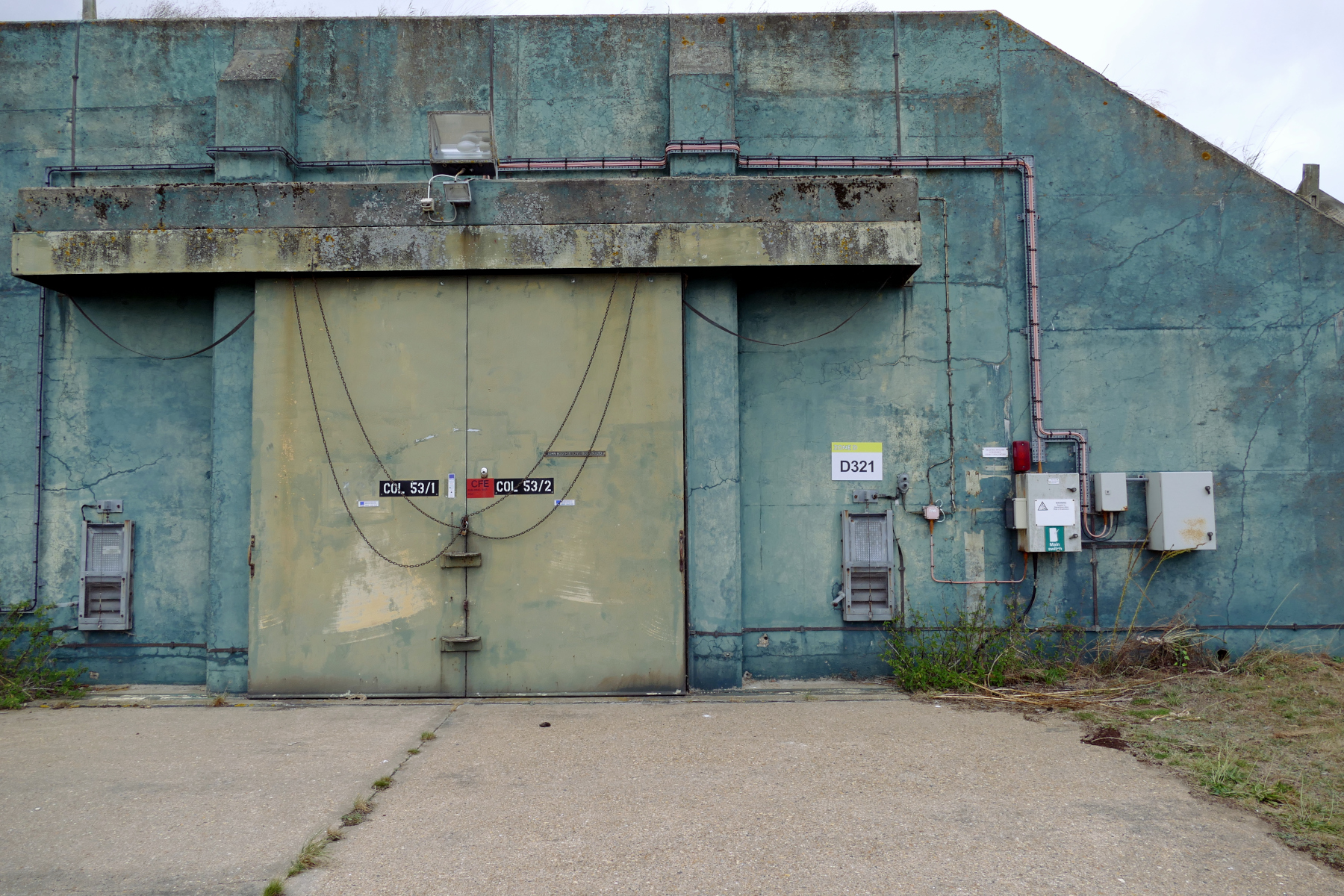 Close up of original Cold War bunker with blue front wall, green blast door