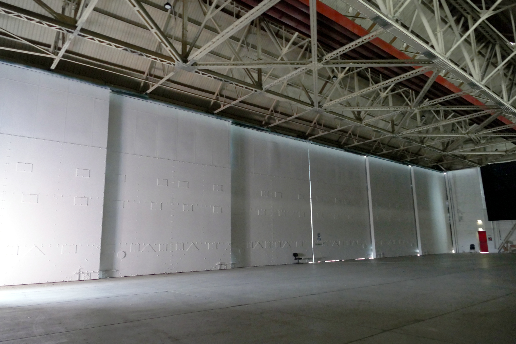 Interior of original RAF aircraft hangar with very large white metal door backdrop